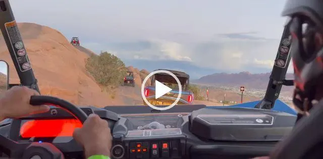 POV shot from inside a UTV following another vehicle down a rocky Moab trail