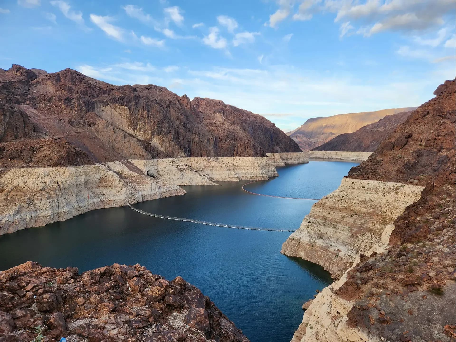 Aerial view of the blue-green Colorado River winding between red and tan canyon cliffs