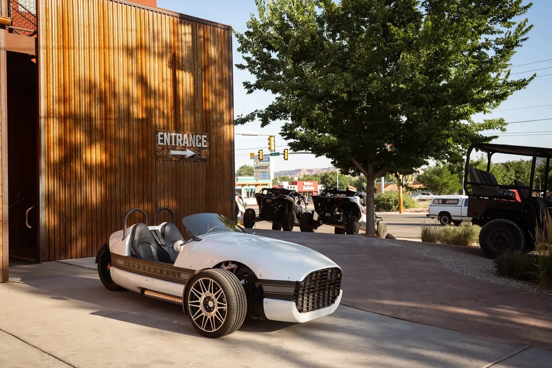 White three-wheeled Vanderhall autocycle parked outside the High Point Hummer shop entrance