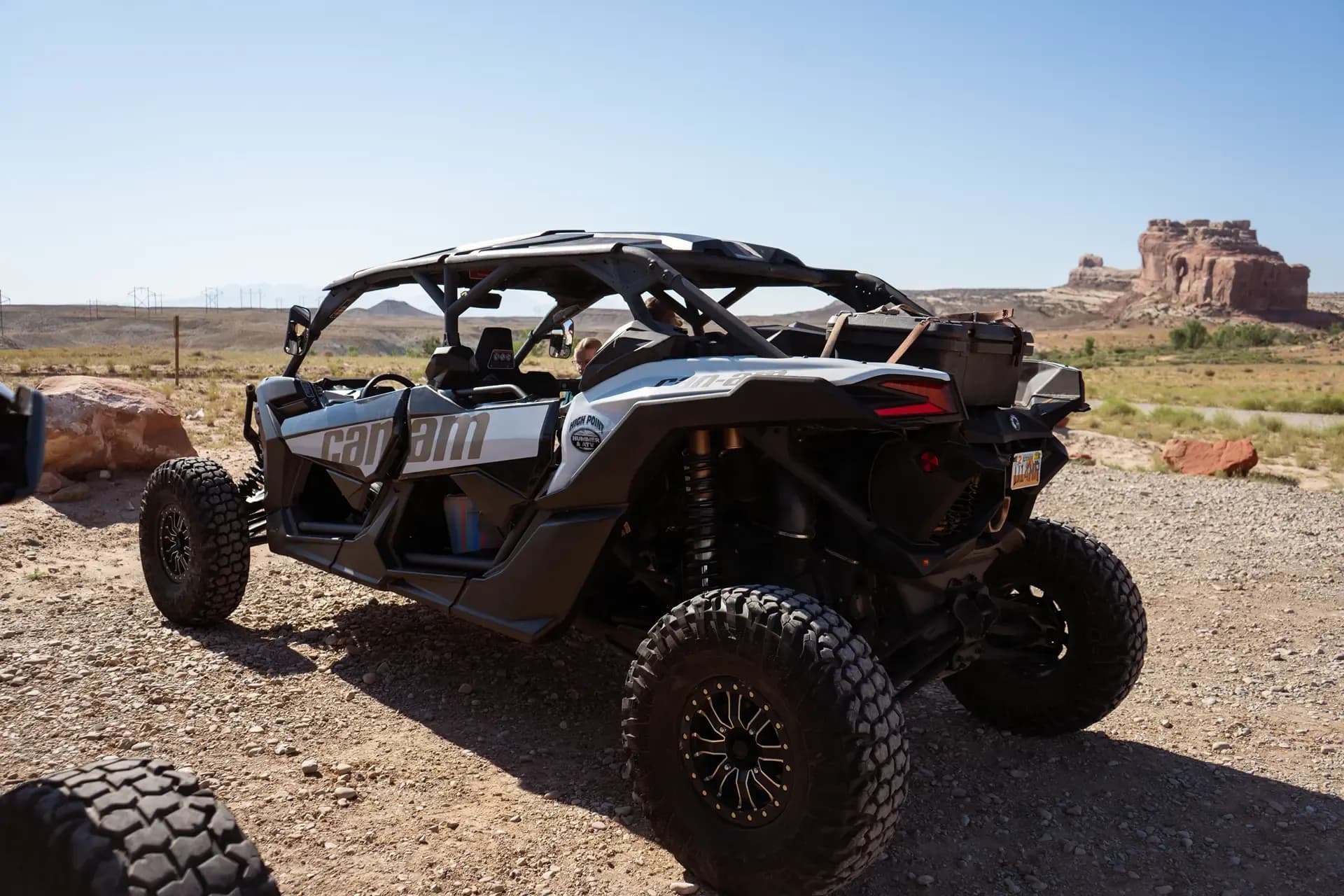 Close-up rear view of a Can-Am UTV parked in the desert with red rock formations behind