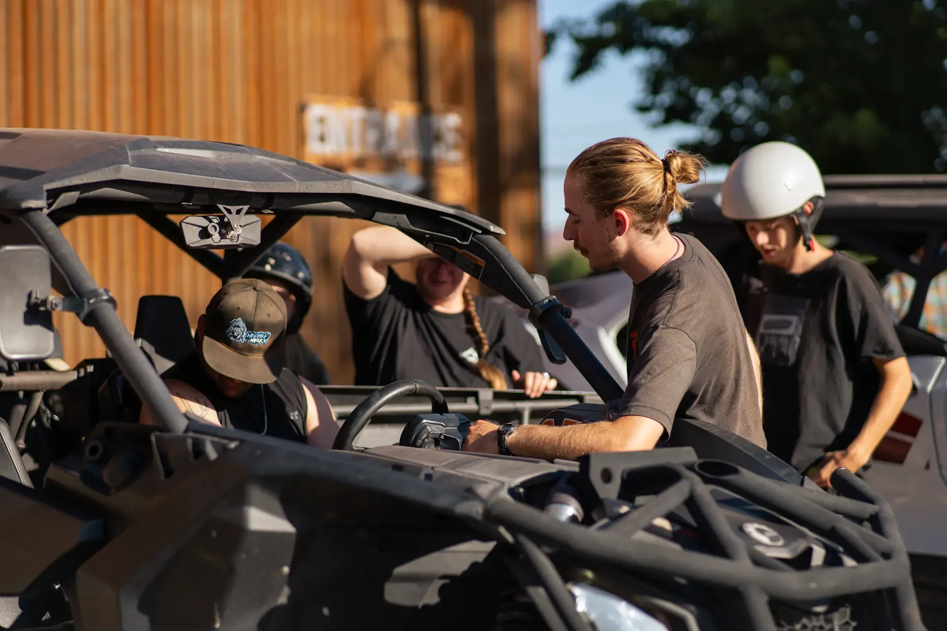 High Point staff helping helmeted guests get settled in a Can-Am side-by-side outside the shop