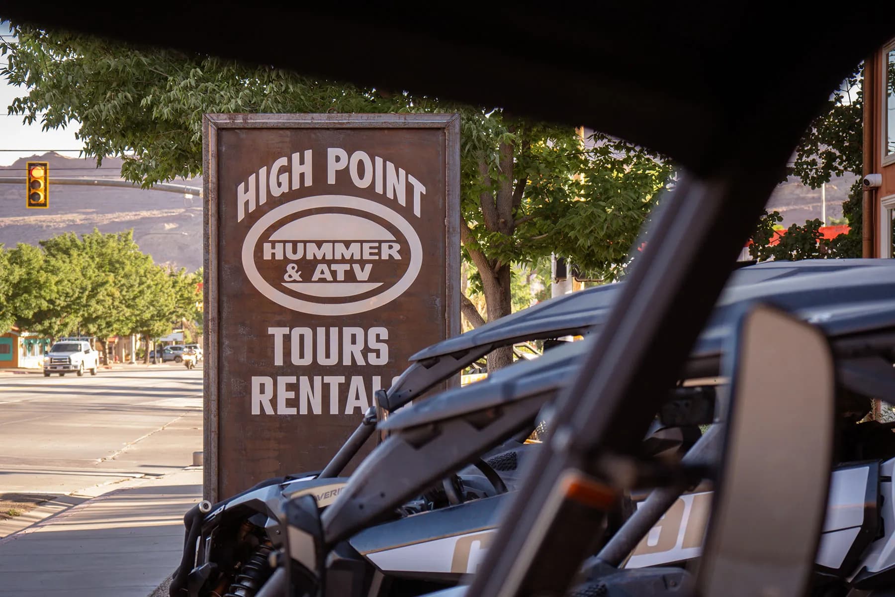The High Point Hummer & ATV Tours and Rentals sign on the street, seen past a parked Can-Am side-by-side