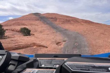 Driver's-seat view from a UTV heading up a steep slickrock fin