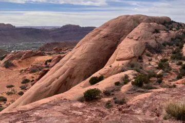 Steep red slickrock fins rising above the Moab valley