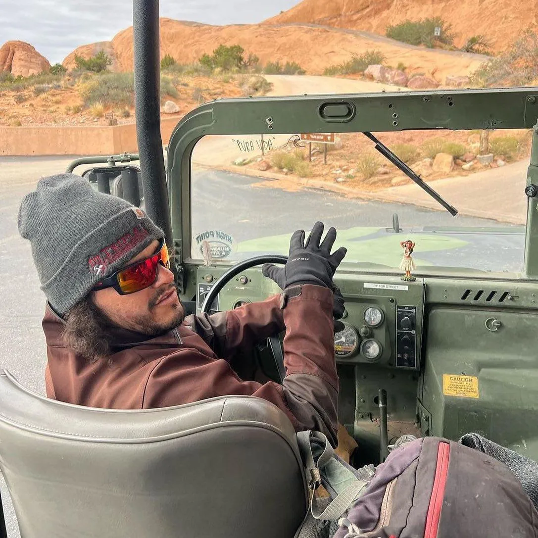 Guide in a beanie and sunglasses at the wheel of a Hummer