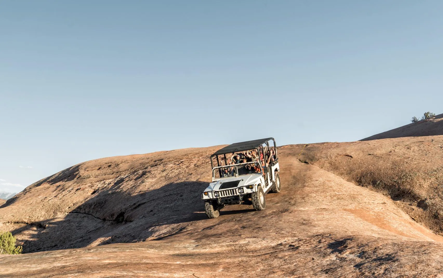 Hummer tour on Hell's Revenge. White hummer descending a sleep section of slickrock on famous Hell's Revenge 4x4 trail in Moab Utah 