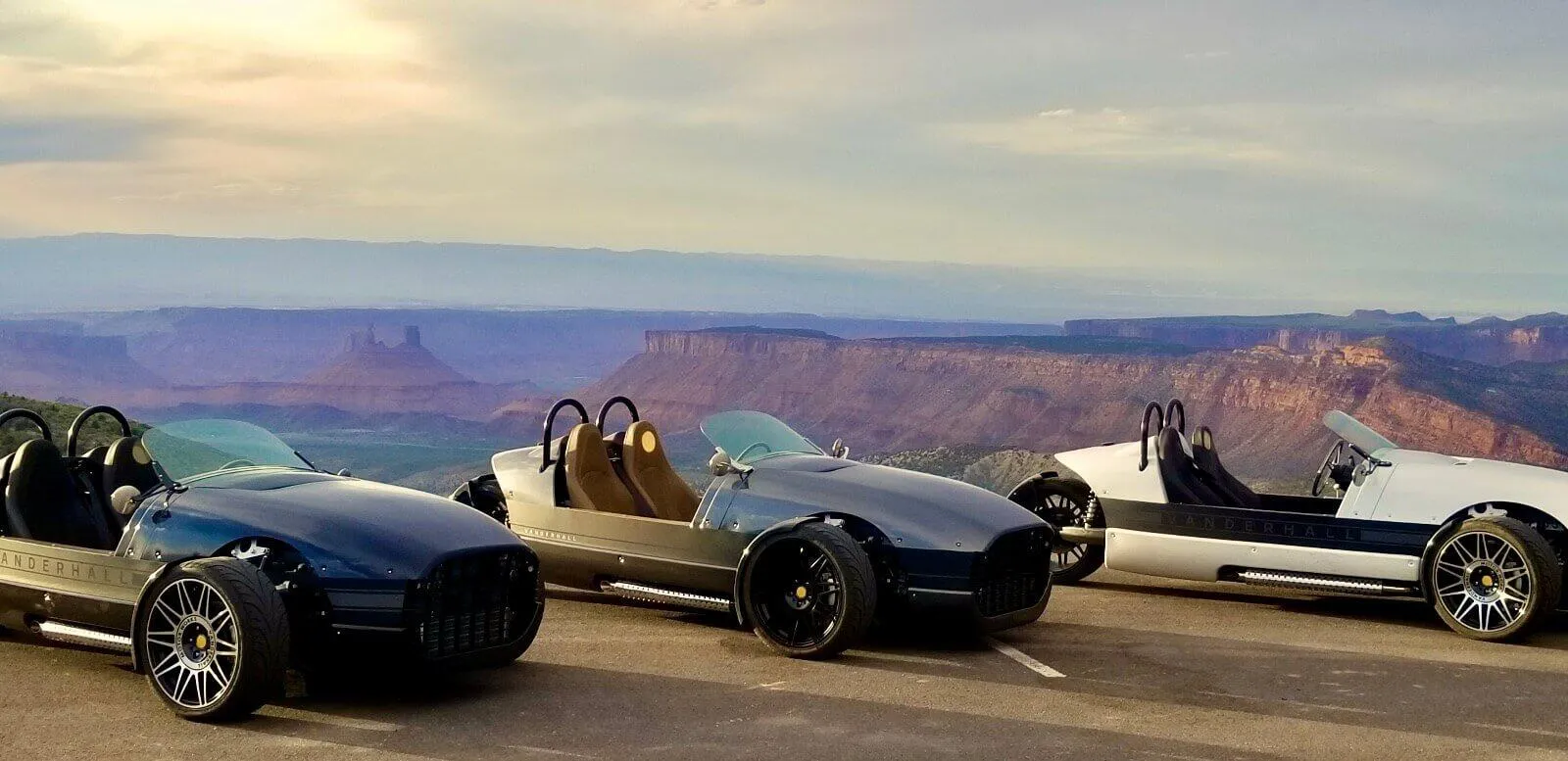 Three Vanderhall three-wheelers lined up at a canyon overlook
